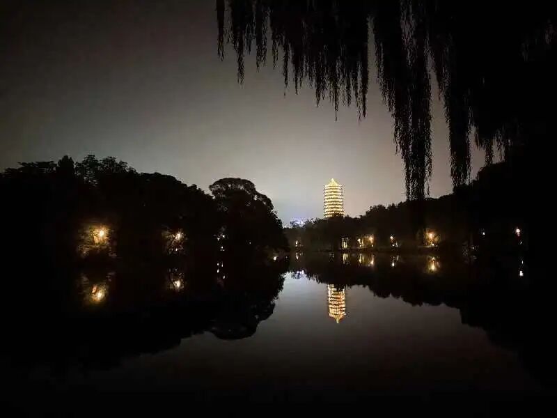 夜晚未名湖倒映着远处燕园宝塔灯光