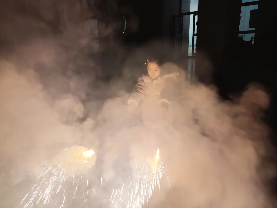 小女孩在烟雾弥漫的烟花爆竹中嬉笑