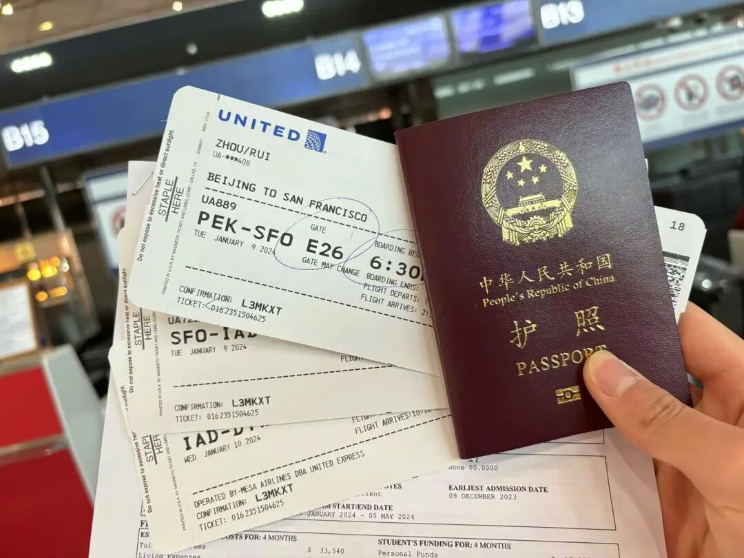 手持护照与北京至旧金山的登机牌