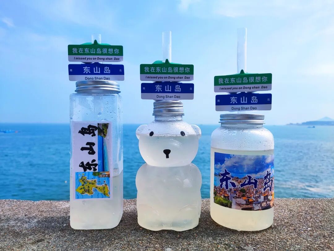 东山岛旅游纪念饮品三瓶摆在海边石墙上